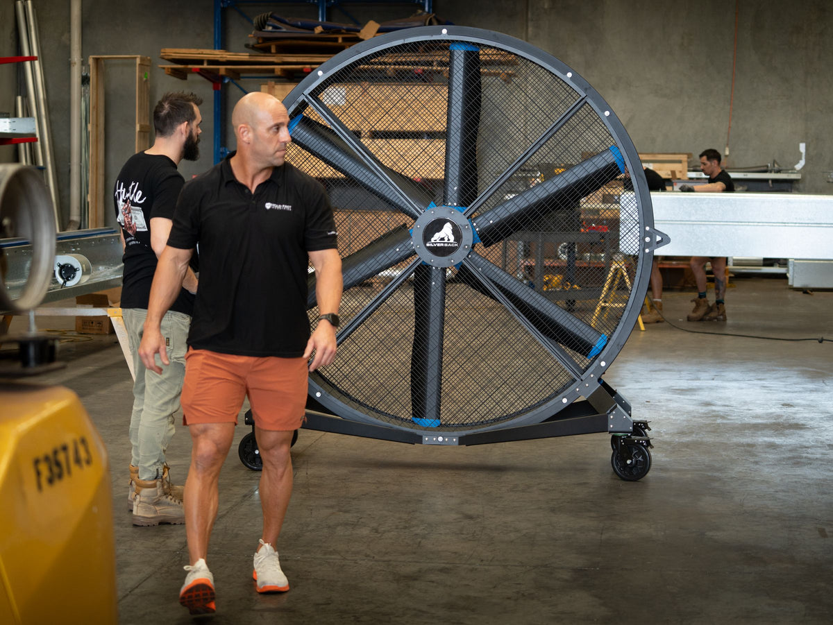 Team member walking past a Switchblade fan in a factory
